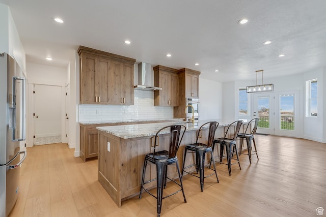 1993 S 5000 W, Taylor, UT 84401 - kitchen with wall chimney range hood, a large island with sink, light wood-style flooring, appliances with stainless steel finishes, and recessed lighting