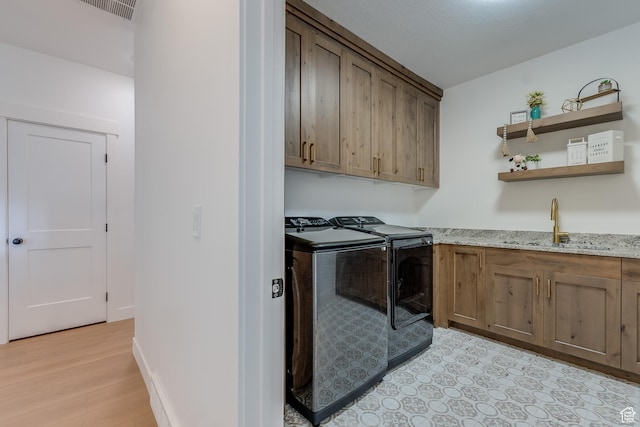 1993 S 5000 W, Taylor, UT 84401 - laundry room with washing machine and clothes dryer, light wood-style flooring, a sink, visible vents, and cabinet space