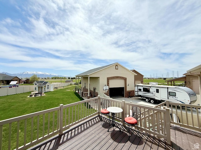deck with fence private yard, an outdoor structure, and a lawn