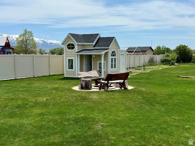 back of property featuring a lawn, roof with shingles, and a fenced backyard