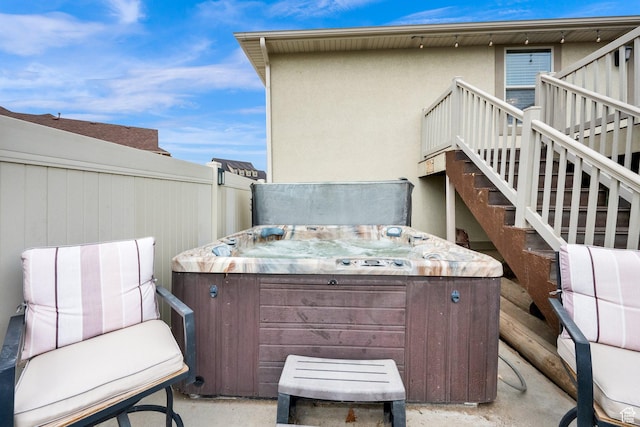 view of patio / terrace featuring fence, stairway, a deck, and a hot tub