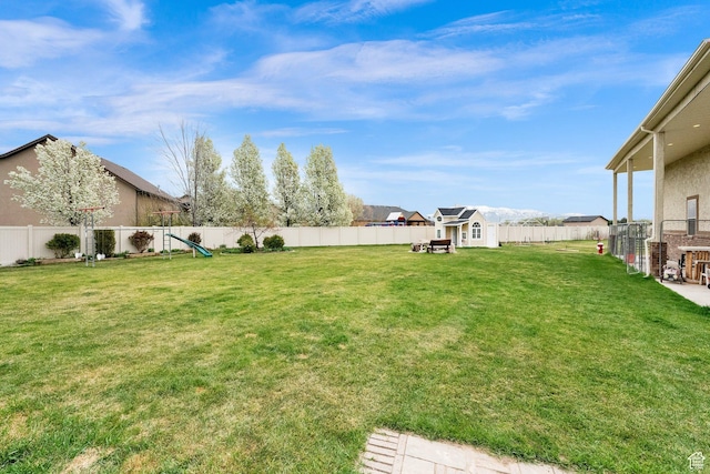 view of yard featuring a fenced backyard, a shed, and an outdoor structure