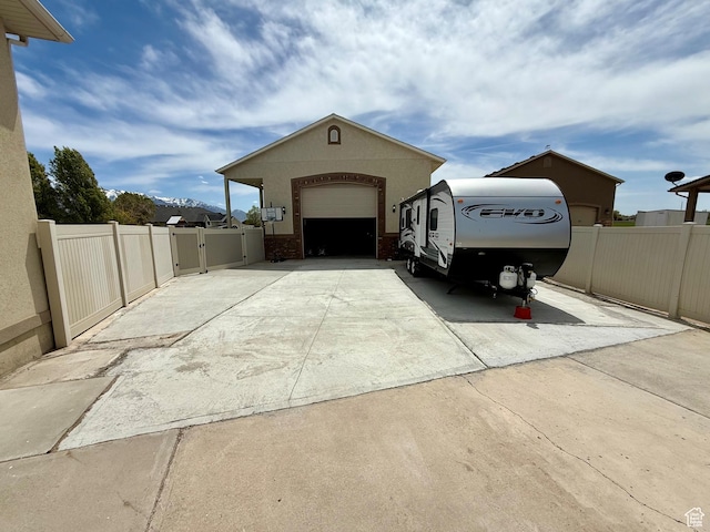 exterior space with a garage, fence, a gate, and concrete driveway