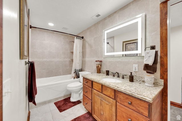 full bathroom featuring tile walls, shower / bath combo with shower curtain, toilet, and vanity