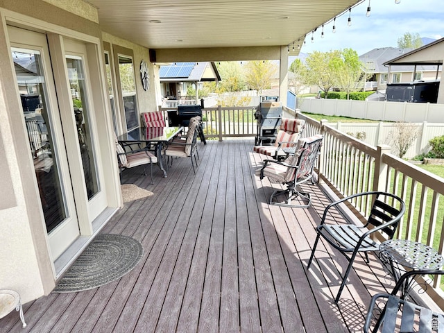wooden deck featuring a residential view, outdoor dining area, and fence