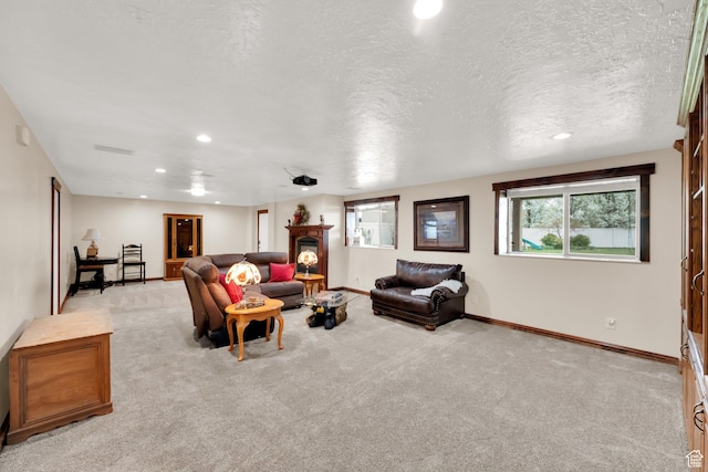 carpeted living room featuring a textured ceiling, recessed lighting, and baseboards
