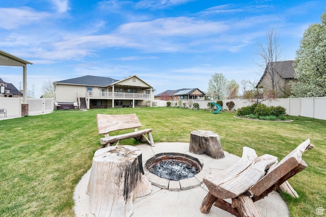 view of yard with a patio, a wooden deck, a fire pit, and a fenced backyard