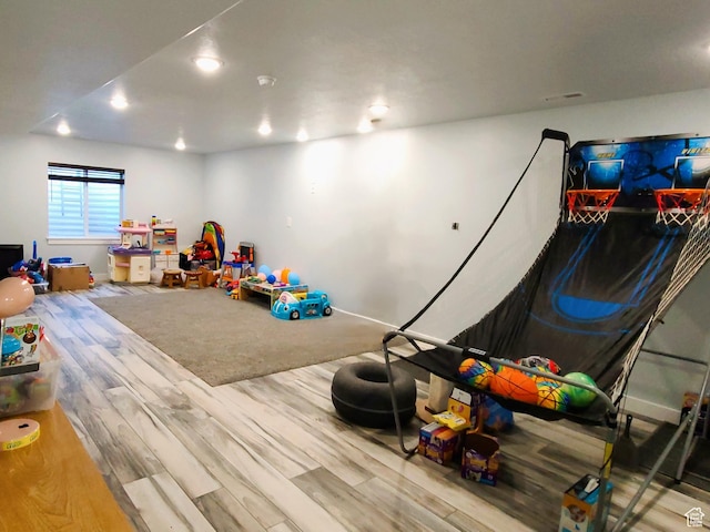 recreation room with wood finished floors and recessed lighting