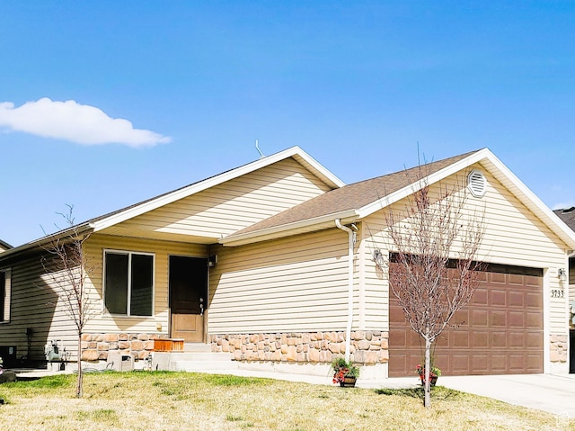 ranch-style home featuring entry steps, an attached garage, stone siding, and driveway