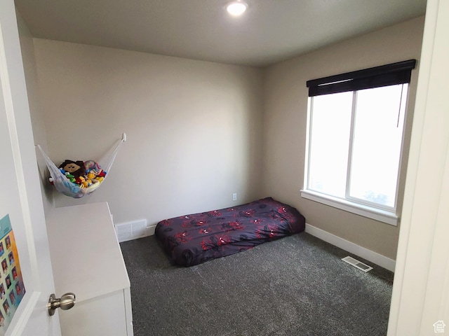 carpeted bedroom featuring baseboards and visible vents