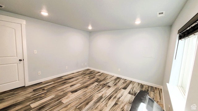 unfurnished room with visible vents, baseboards, wood finished floors, and recessed lighting