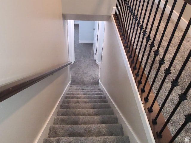 stairway with baseboards and carpet