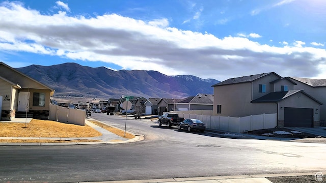 view of street featuring a residential view, sidewalks, a mountain view, traffic signs, and curbs