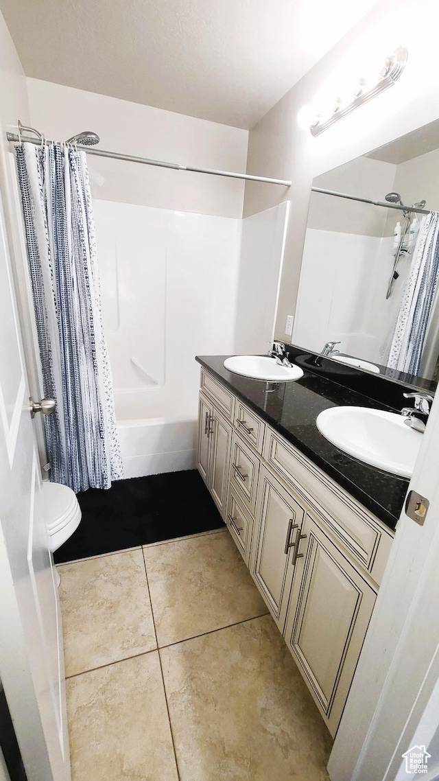 full bath with tile patterned floors, shower / tub combo with curtain, a sink, and double vanity