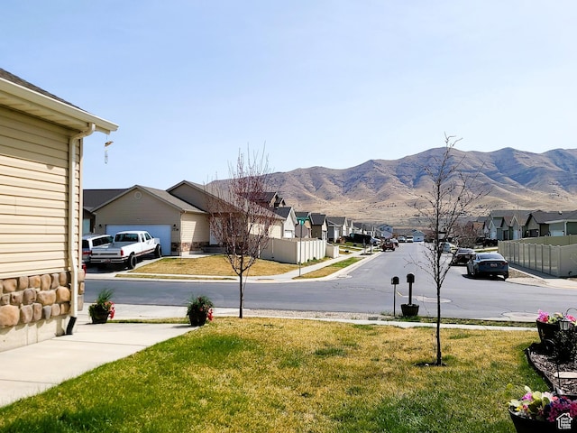 view of road with sidewalks, a mountain view, and a residential view