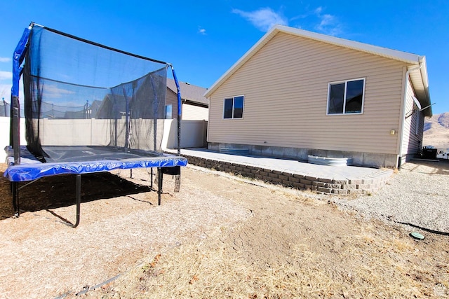 rear view of house featuring a trampoline