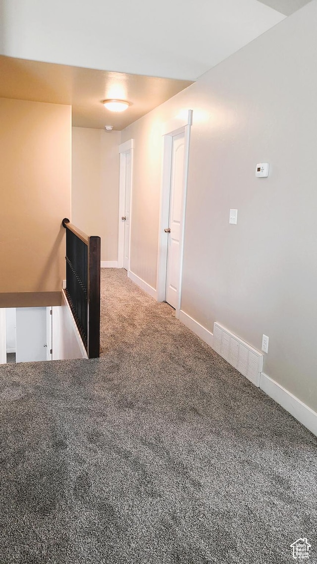 carpeted empty room featuring baseboards and visible vents