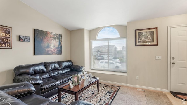 carpeted living area with lofted ceiling, baseboards, and visible vents
