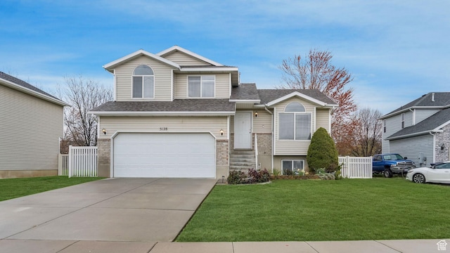 view of front of home featuring concrete driveway, a front lawn, a shingled roof, fence, and a garage