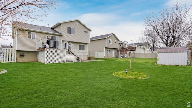 rear view of house featuring a storage unit, an outbuilding, a fenced backyard, and a lawn