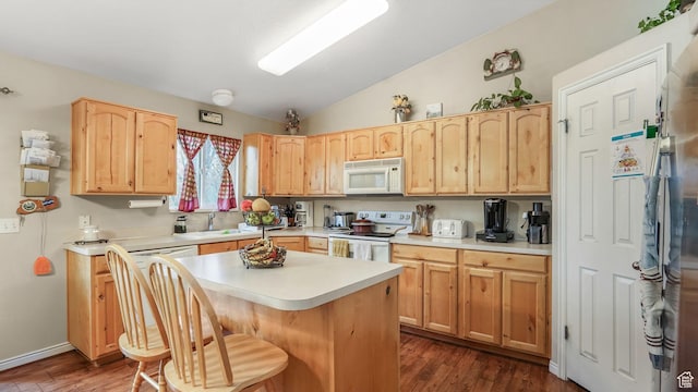 kitchen with a center island, lofted ceiling, white appliances, light brown cabinets, and light countertops