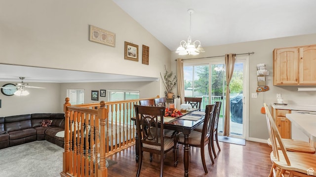 dining space with vaulted ceiling, wood finished floors, and ceiling fan with notable chandelier