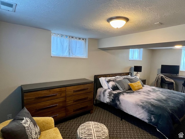 715 Oak Dr, Brigham City, UT 84302 - bedroom with dark carpet, visible vents, and a textured ceiling