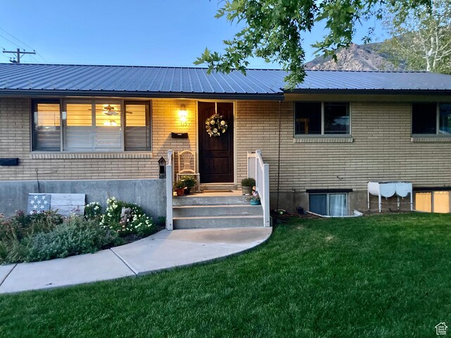 715 Oak Dr, Brigham City, UT 84302 - bi-level home featuring a front lawn, brick siding, and metal roof