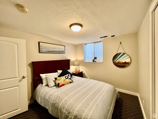 715 Oak Dr, Brigham City, UT 84302 - bedroom with dark carpet, baseboards, a textured ceiling, and visible vents