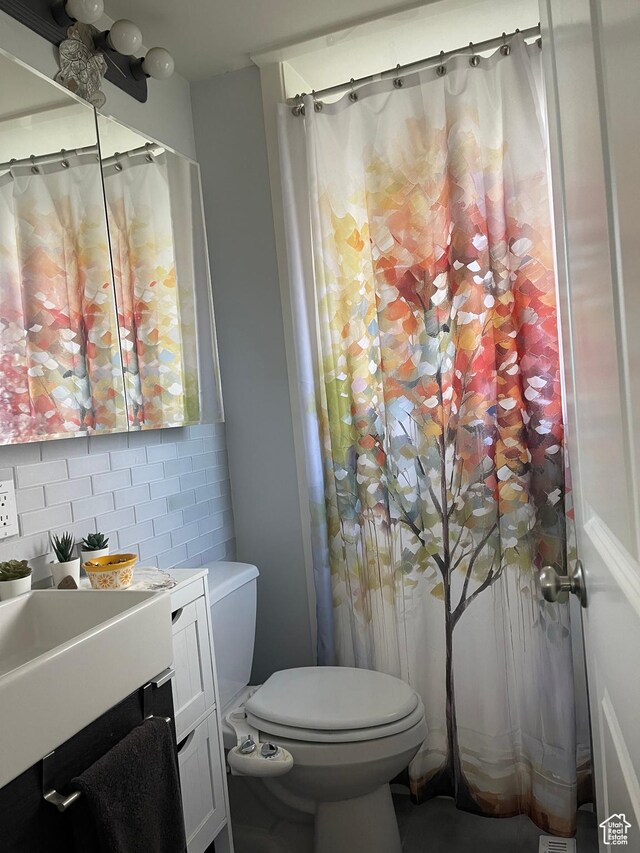 715 Oak Dr, Brigham City, UT 84302 - bathroom featuring vanity, backsplash, and toilet
