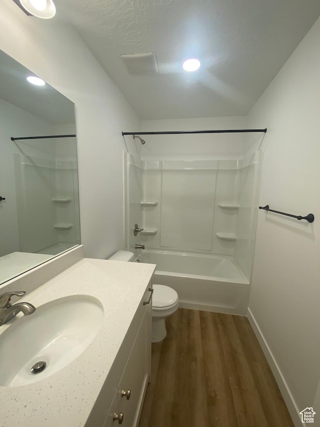 bathroom featuring wood finished floors, vanity, shower / washtub combination, toilet, and visible vents