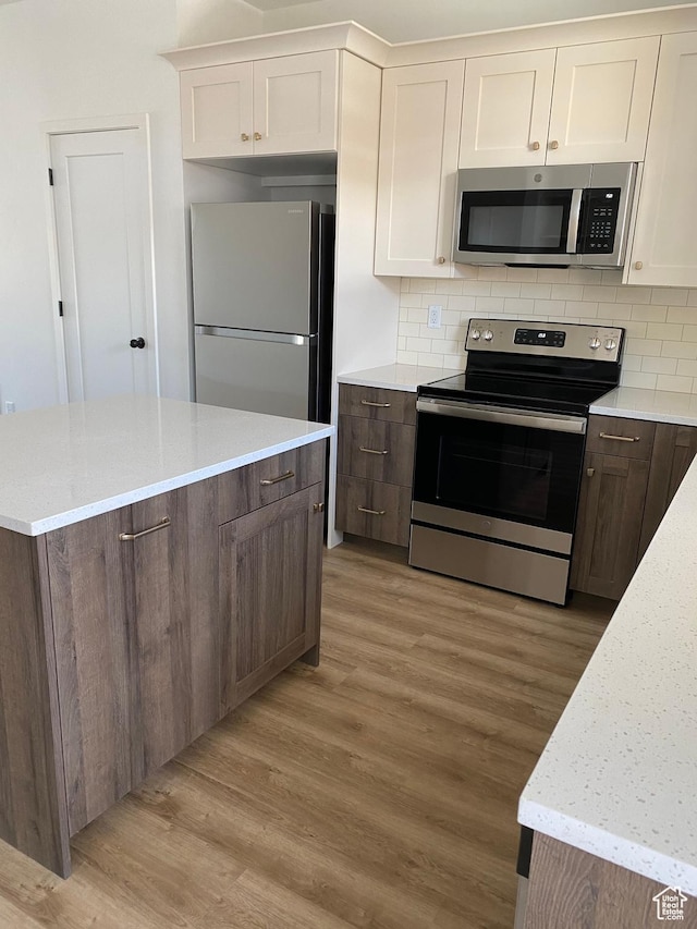 kitchen featuring decorative backsplash, stainless steel appliances, and light wood finished floors