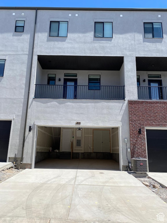 exterior space with central AC unit, driveway, and a garage