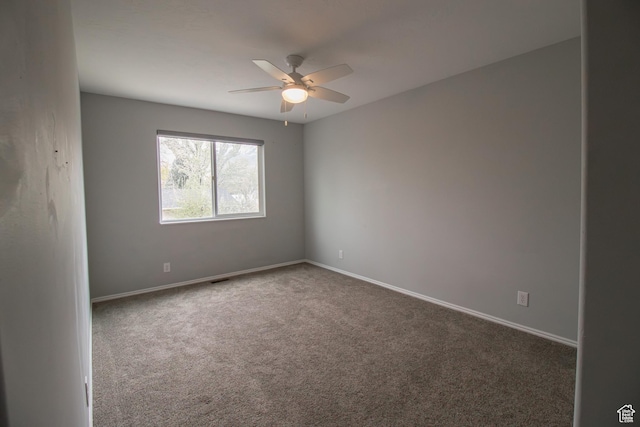 spare room with ceiling fan, baseboards, and carpet flooring