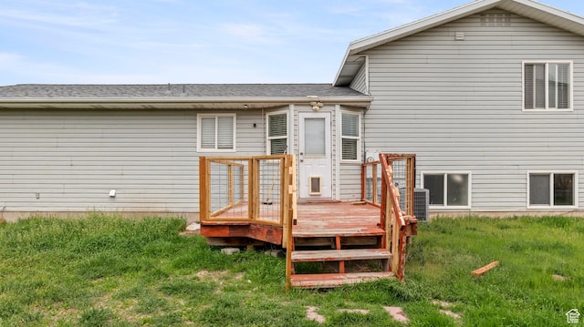 rear view of property with a shingled roof and a deck