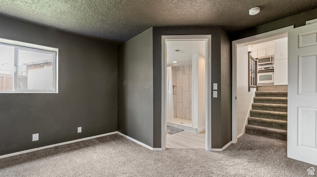 unfurnished bedroom with a spacious closet, baseboards, a closet, and carpet
