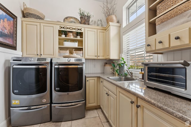 washroom with a toaster, washing machine and dryer, a wealth of natural light, and a sink