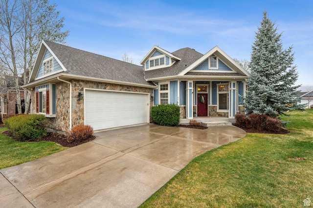 view of front of property with a front lawn, concrete driveway, an attached garage, stone siding, and roof with shingles