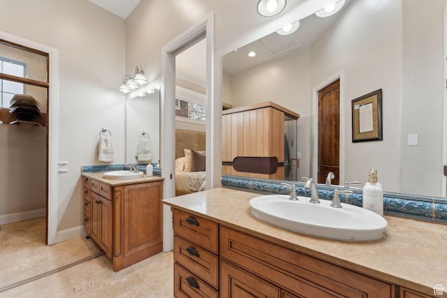 bathroom featuring two vanities, tile patterned floors, baseboards, and a sink