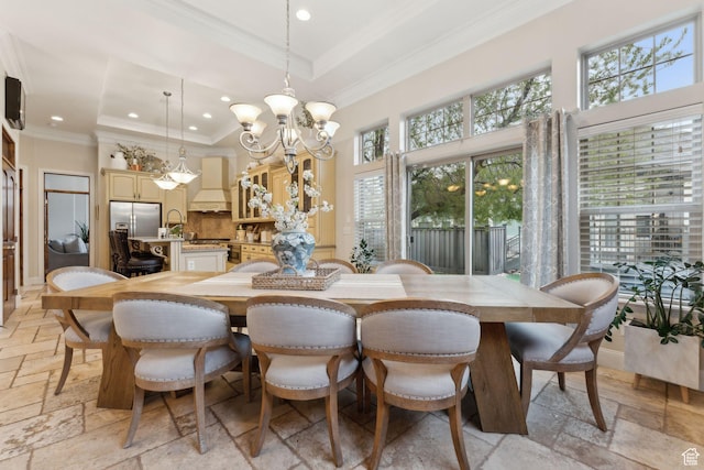 dining room with an inviting chandelier, stone tile flooring, a tray ceiling, and recessed lighting