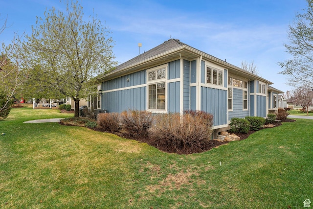 view of home's exterior with board and batten siding and a yard