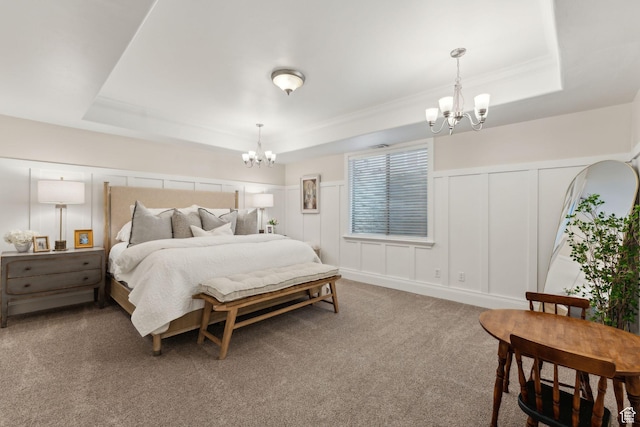 carpeted bedroom featuring a notable chandelier, a raised ceiling, and a decorative wall