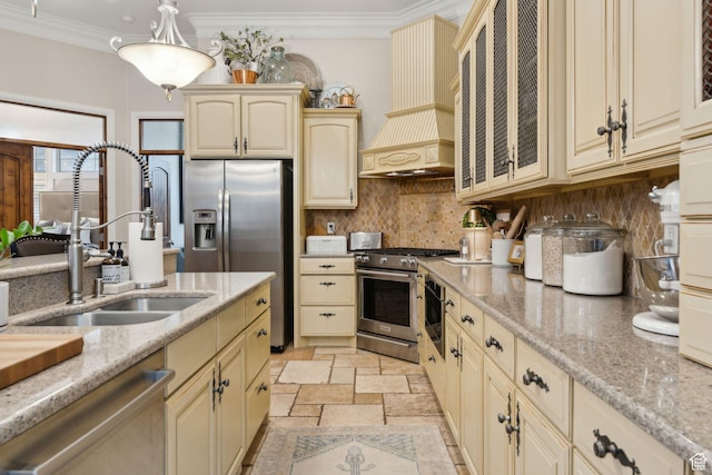 kitchen featuring premium range hood, cream cabinetry, stainless steel appliances, and a sink