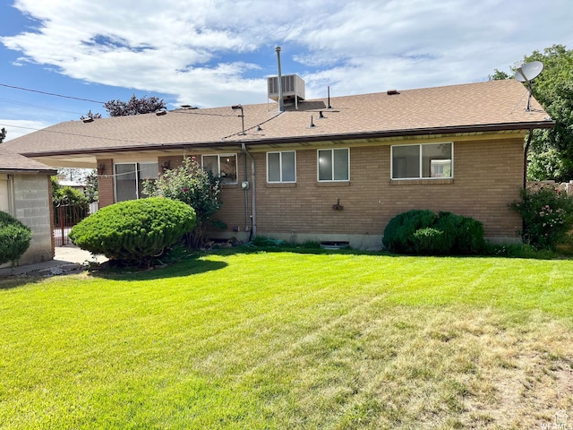 394 E Bridlewood Dr S, Salt Lake City, UT 84107 - rear view of house with roof with shingles, brick siding, a yard, and central AC unit