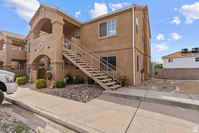view of property featuring stairway and fence