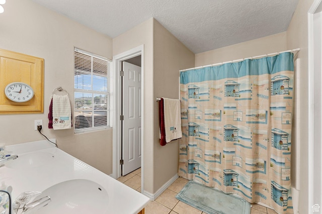 bathroom featuring a shower with shower curtain, double vanity, tile patterned flooring, and a sink