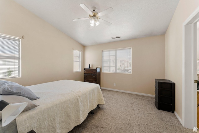 carpeted bedroom with vaulted ceiling, a ceiling fan, visible vents, and baseboards