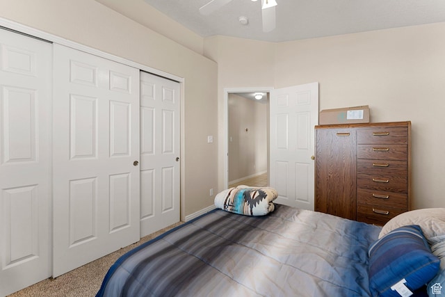 bedroom with dark colored carpet, a closet, and a ceiling fan
