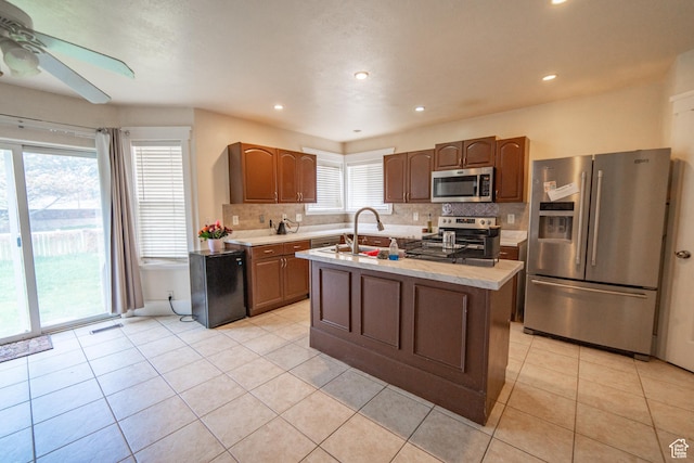 1137 S Topaz Rd, Saratoga Springs, UT 84045 - kitchen with stainless steel appliances, ceiling fan, light countertops, tasteful backsplash, and light tile patterned floors