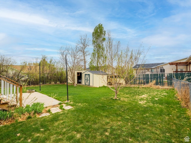 view of yard with a fenced backyard, an outdoor structure, a patio area, and a shed